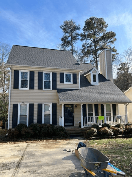 Roof Installation — Two-story house with a newly installed dark gray shingle roof, showing the completed project