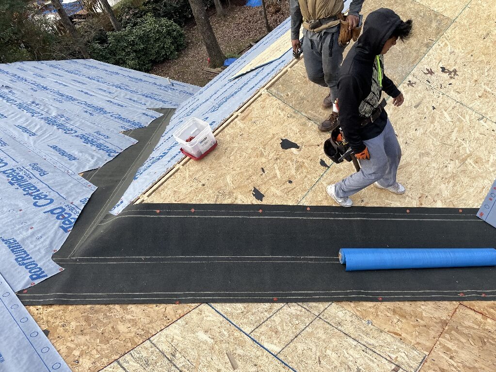 Roof Repair — Roofers installing underlayment and ice and water shield on a plywood roof deck